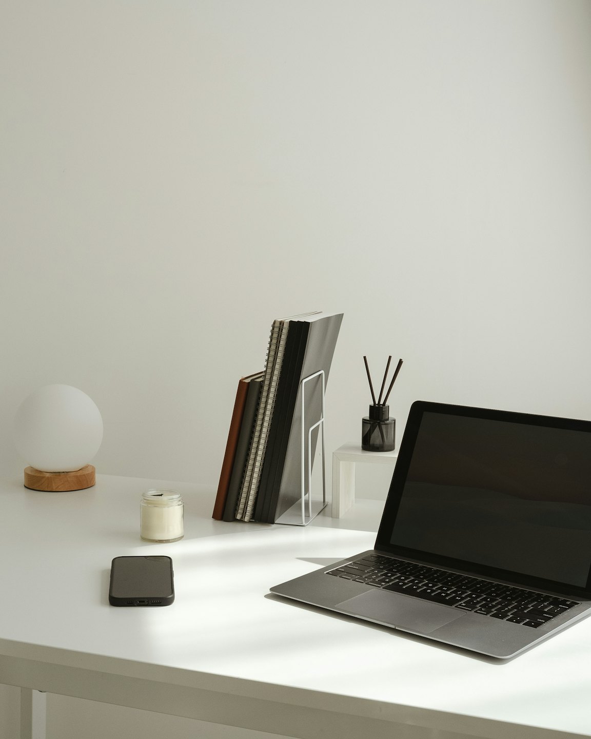 Laptop e accessori da scrivania disposti ordinatamente su una scrivania di legno.