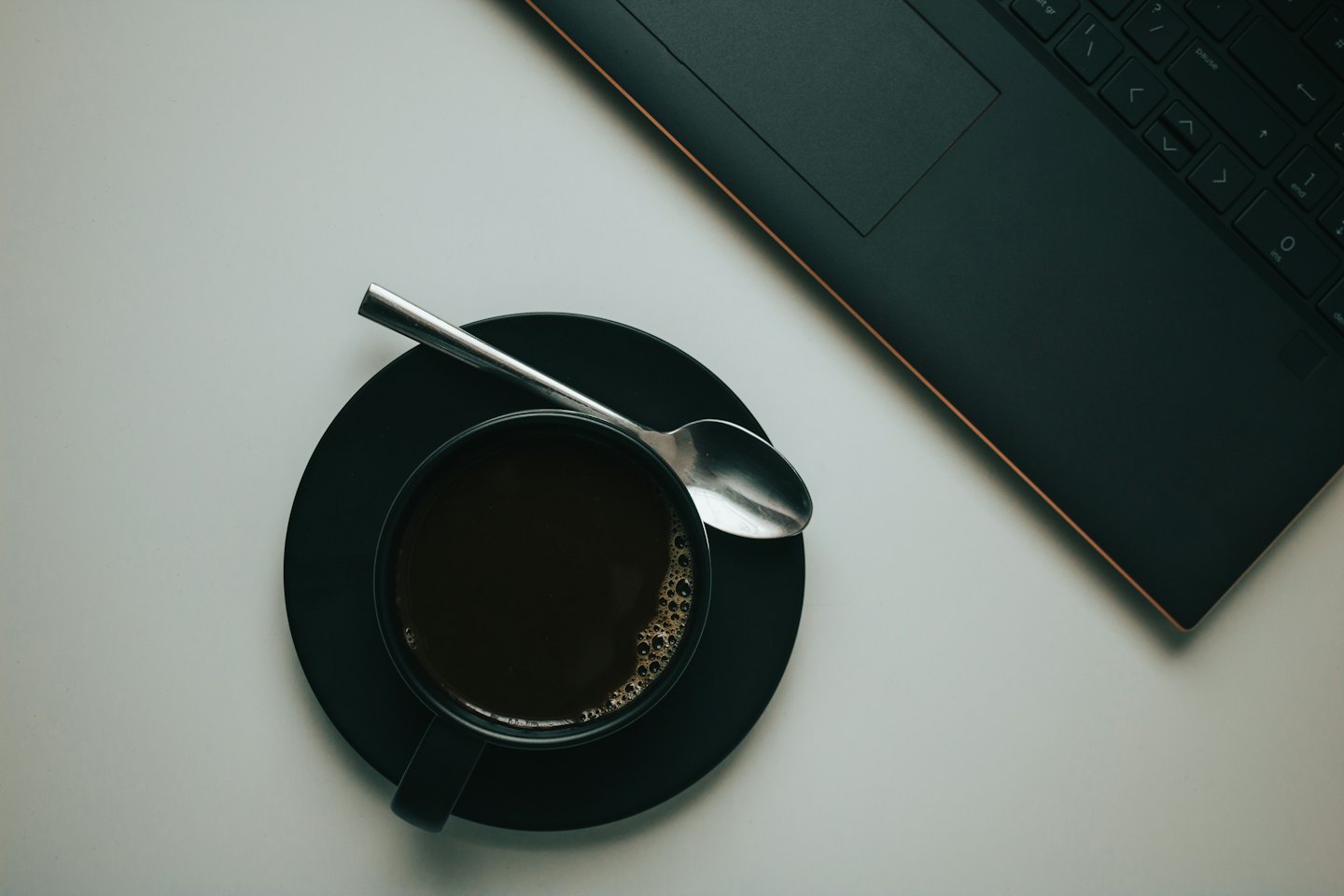 Vista dall'alto di una tazza di caffè e un laptop su una scrivania.